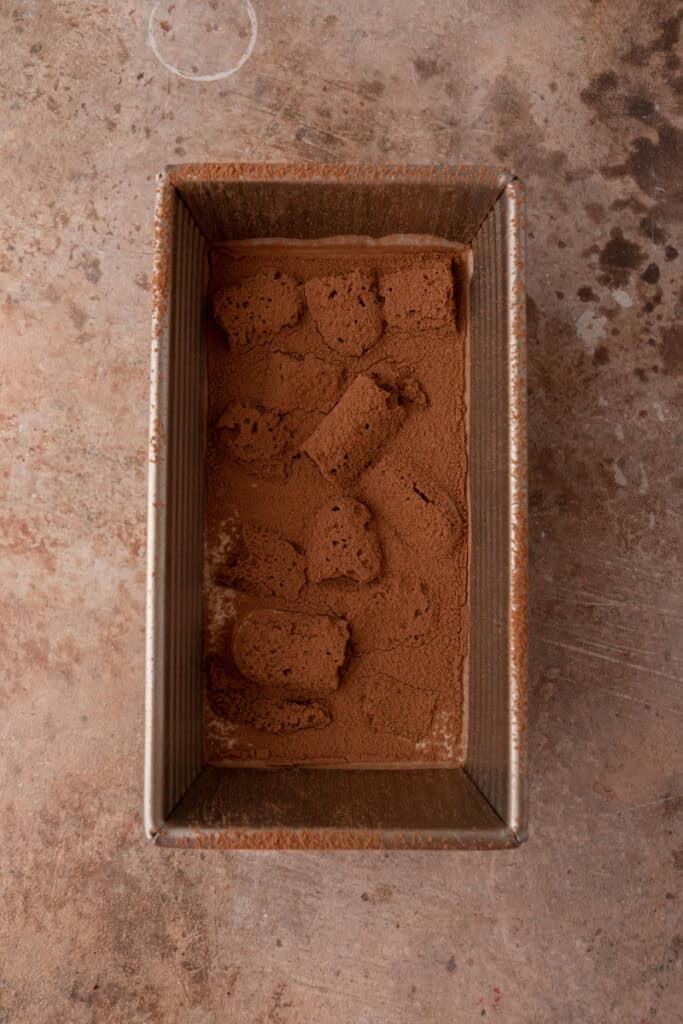 Couche supérieure dans le moule, saupoudrée de cacao