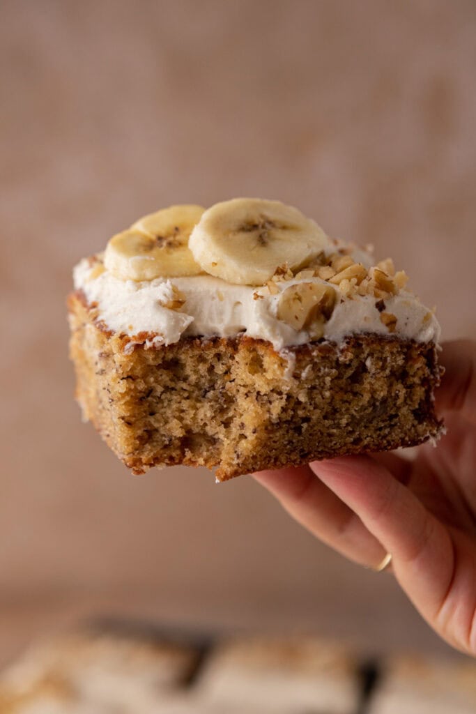Une tranche de gâteau à la banane tenue par une main