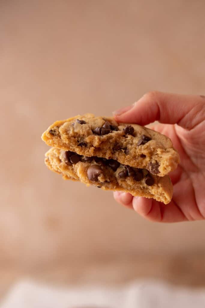 Cookie au beurre de cacahuète et pépites de chocolat tenu en main