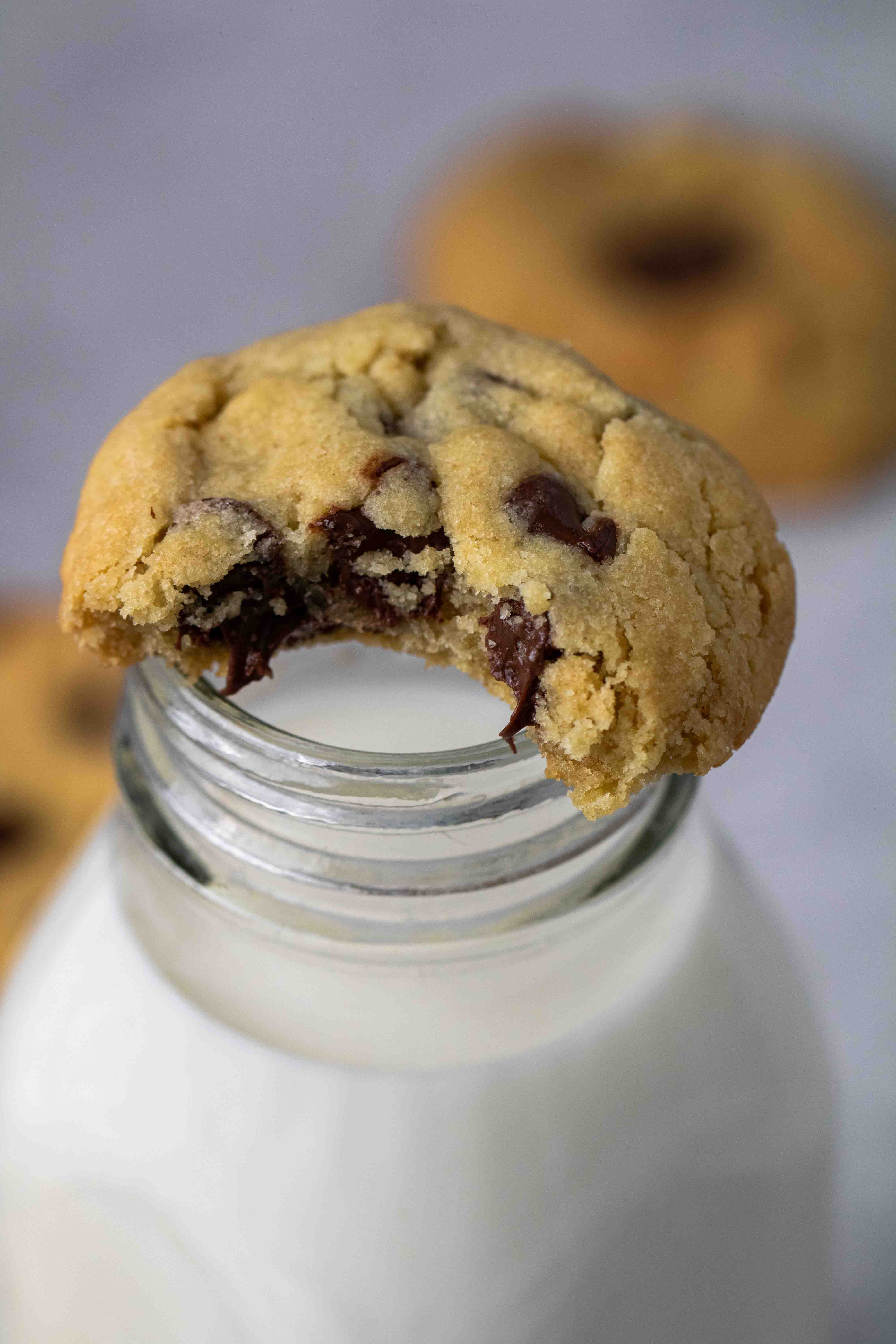 Zoom sur un cookie aux pépites de chocolat sur une bouteille de lait